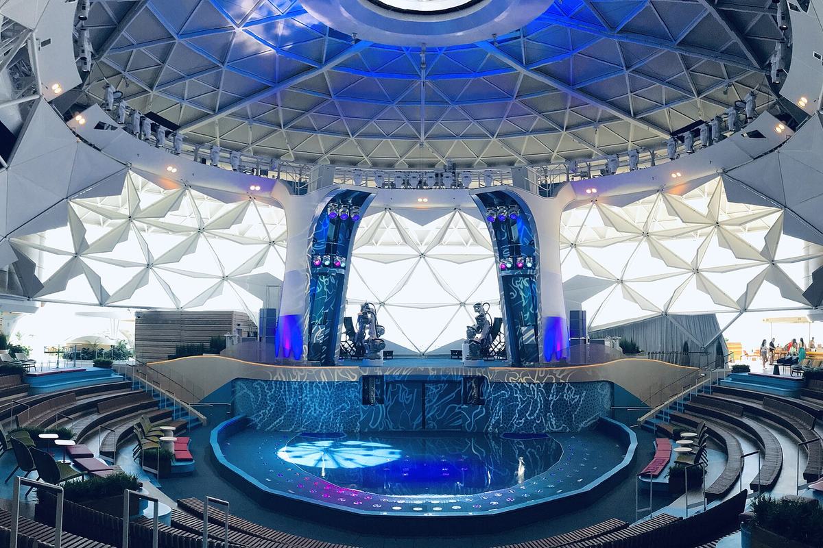 The AquaDome, a glass dome at the bow of Icon of the Seas, with a waterfall and seating below