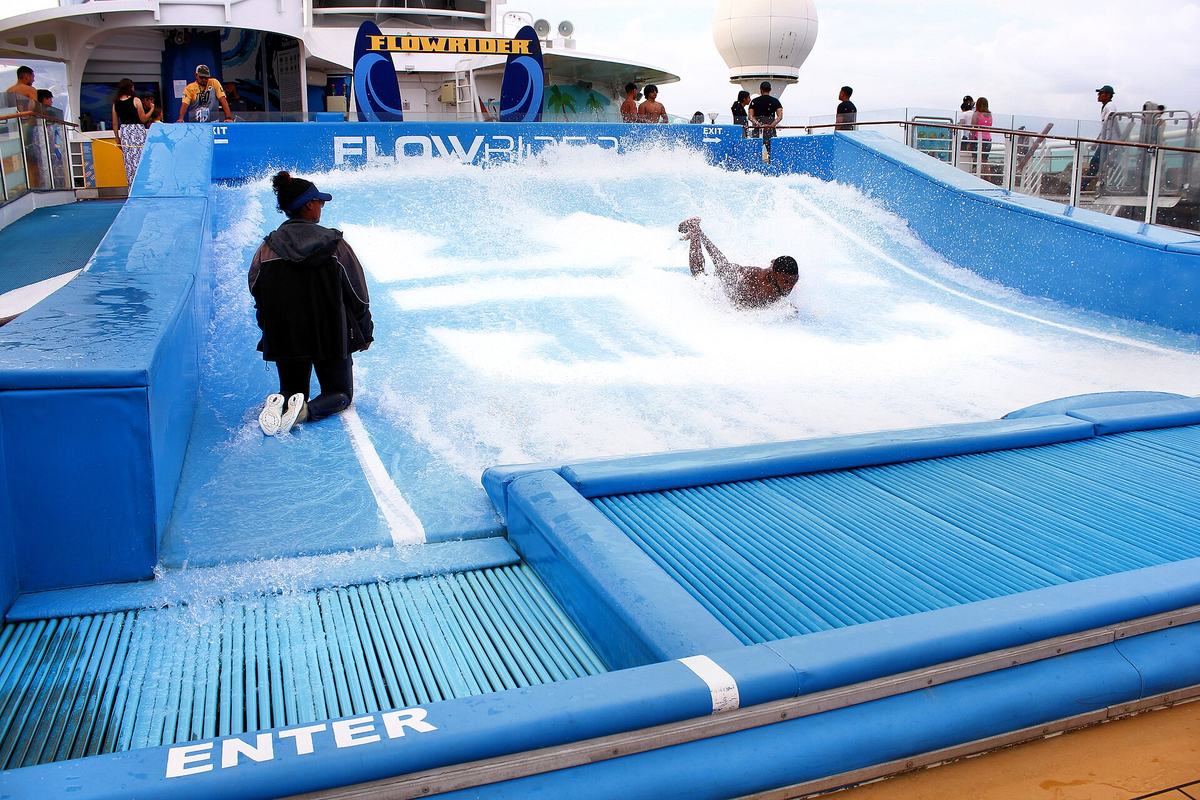 A passenger riding the FlowRider surf simulator on Voyager of the Seas